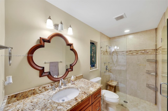 bathroom with vanity, toilet, visible vents, and a stall shower