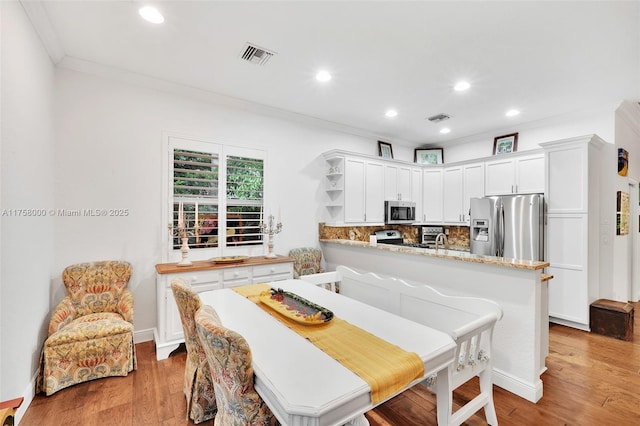 dining area featuring crown molding, recessed lighting, visible vents, and light wood finished floors