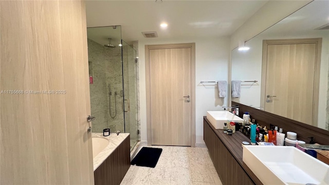 full bathroom with visible vents, double vanity, a sink, a shower stall, and a garden tub