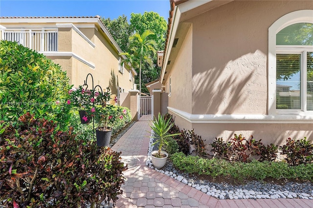 view of side of property with a gate and stucco siding