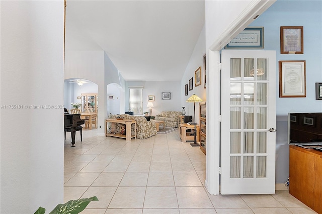 living room featuring arched walkways and light tile patterned flooring