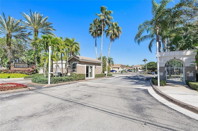 view of street featuring curbs, a gated entry, sidewalks, and a gate