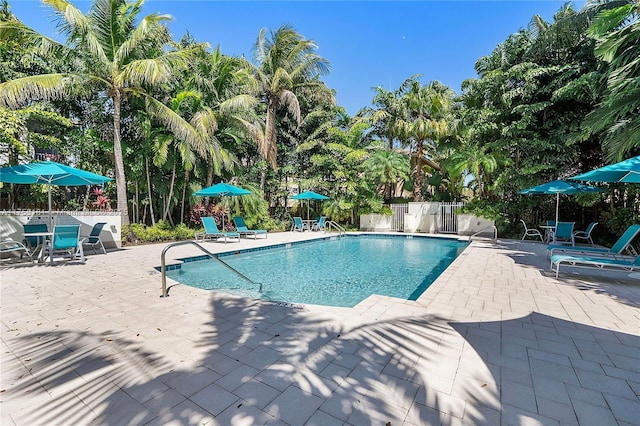 community pool featuring fence and a patio area