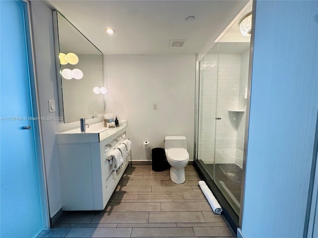 full bathroom with visible vents, toilet, a shower stall, baseboards, and vanity