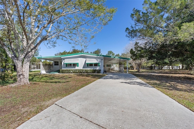 view of front of home with an attached carport, driveway, and a front yard