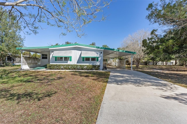 view of front facade with an attached carport, driveway, and a front yard