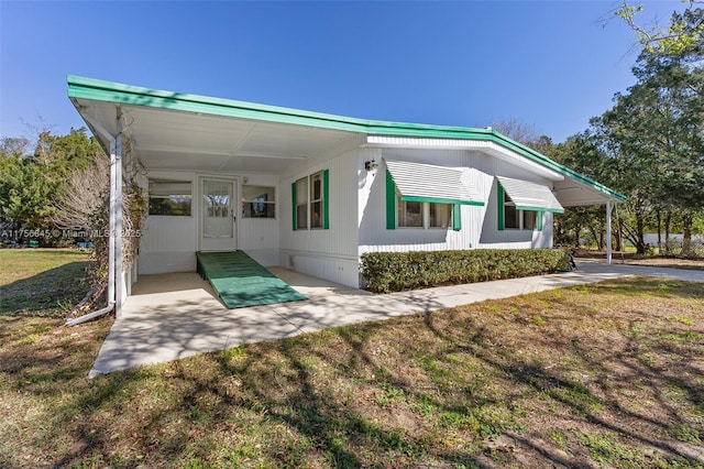 view of front of home with a carport and a front lawn