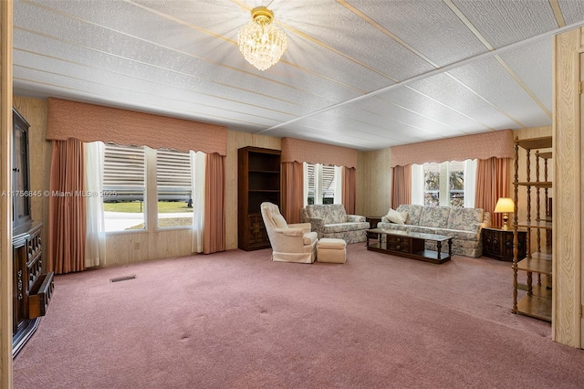 carpeted living area featuring a wealth of natural light, visible vents, and a textured ceiling