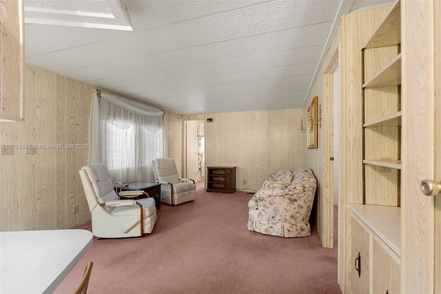 sitting room with carpet floors and wooden walls