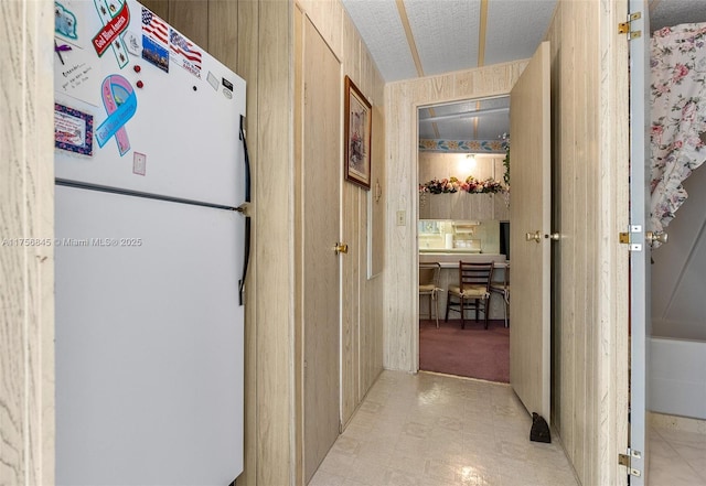 corridor with a textured ceiling and light floors