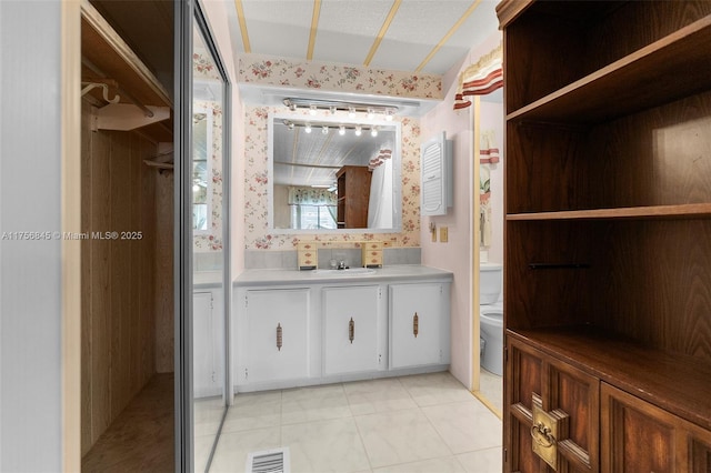 bathroom featuring vanity, tile patterned floors, toilet, and visible vents