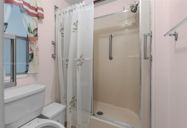 full bathroom with a shower stall and toilet