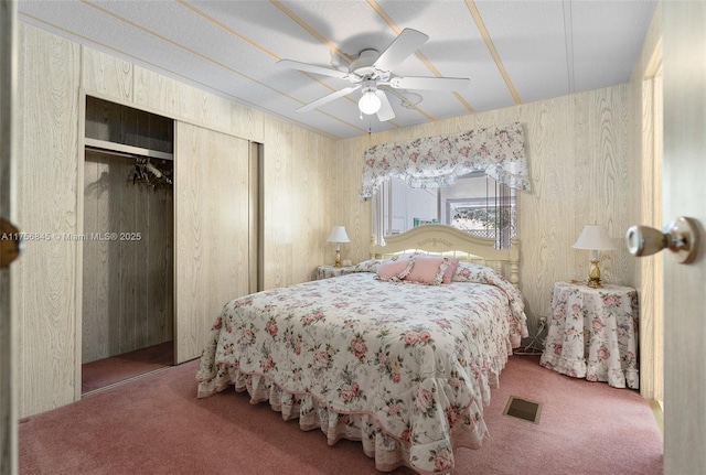 bedroom featuring a closet, visible vents, a ceiling fan, and carpet