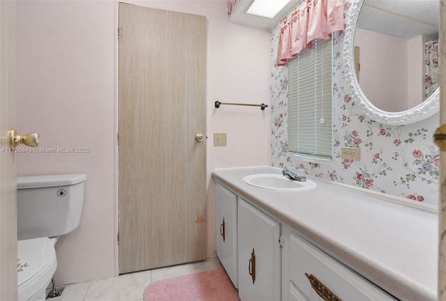 bathroom featuring tile patterned flooring, toilet, and vanity