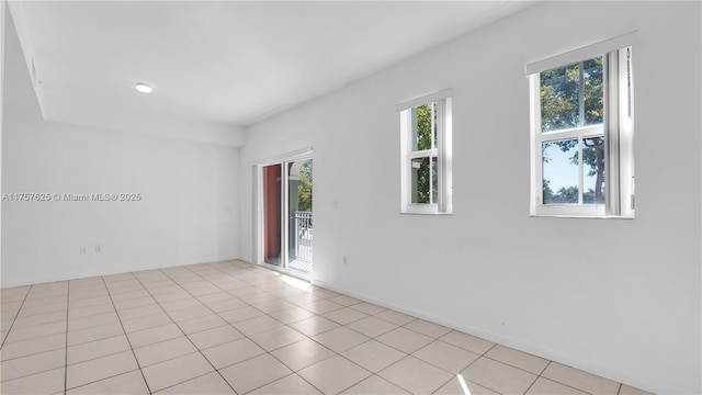 empty room featuring a wealth of natural light and light tile patterned floors