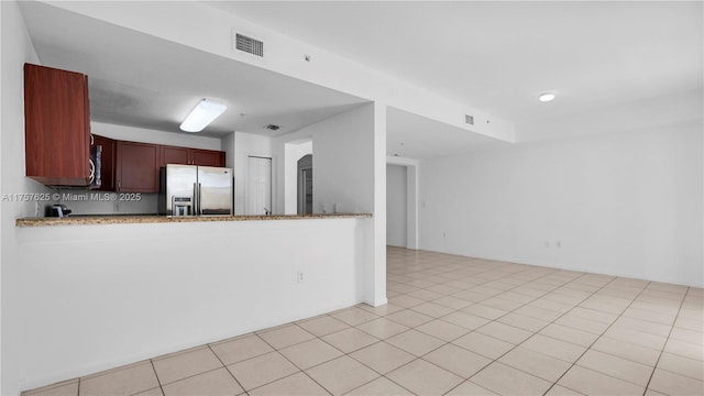 kitchen featuring light tile patterned flooring, visible vents, a peninsula, and stainless steel refrigerator with ice dispenser