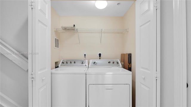 clothes washing area featuring washer and clothes dryer, laundry area, and visible vents