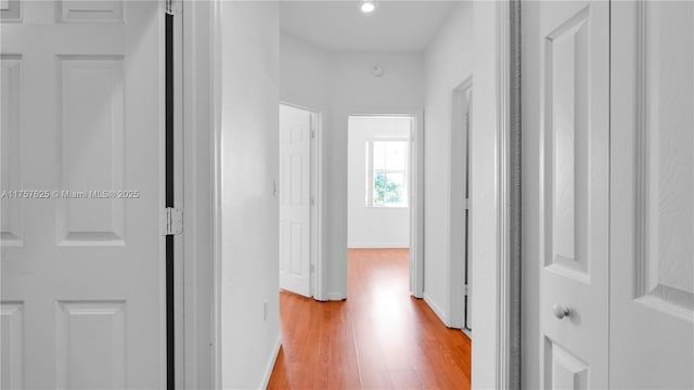 hallway featuring light wood-style floors and baseboards