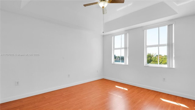 spare room featuring ceiling fan, baseboards, and wood finished floors