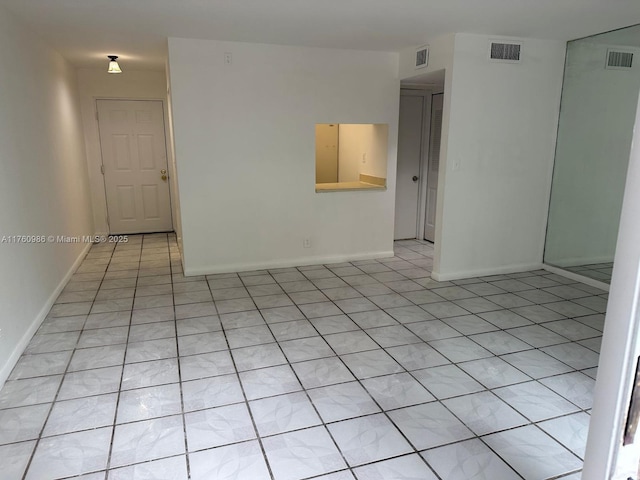 unfurnished room featuring light tile patterned floors, visible vents, and baseboards