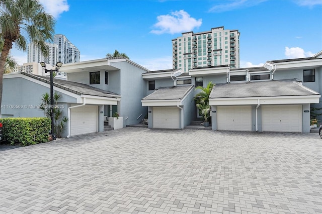 view of front of house featuring decorative driveway, stucco siding, and a tiled roof