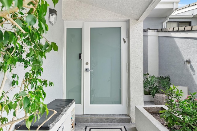 entrance to property featuring stucco siding