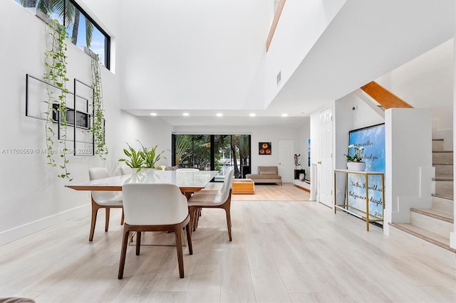 dining space featuring stairway, a healthy amount of sunlight, visible vents, and light wood finished floors