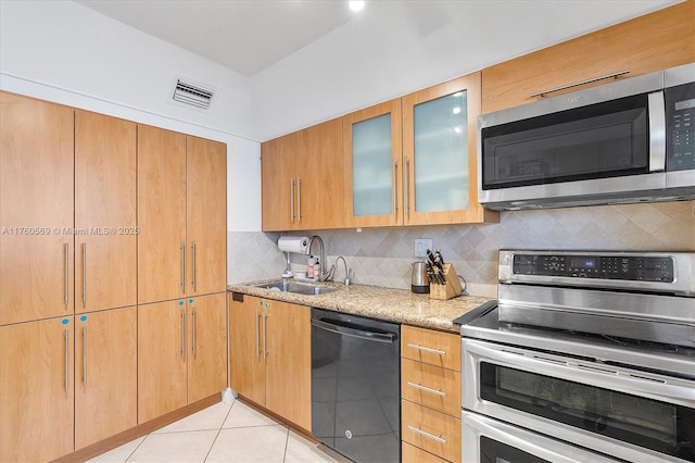 kitchen featuring light stone counters, light tile patterned floors, visible vents, a sink, and stainless steel appliances