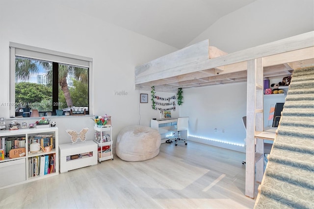 playroom with lofted ceiling and wood finished floors