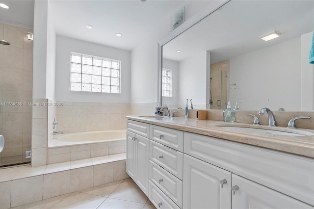 bathroom featuring tile patterned flooring, a stall shower, a bath, and a sink