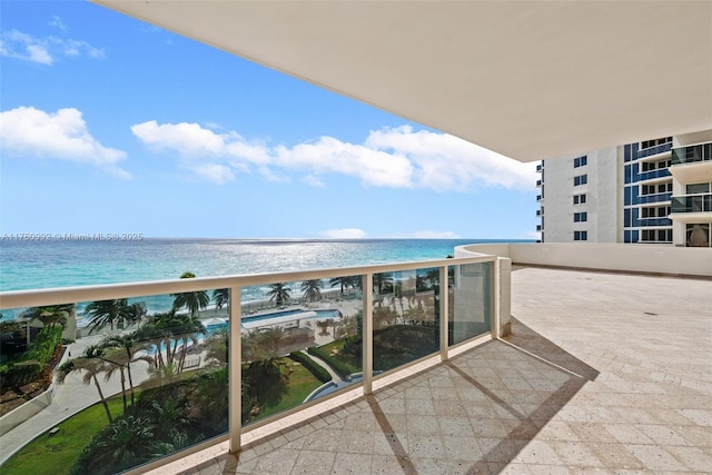 balcony featuring a view of the beach and a water view