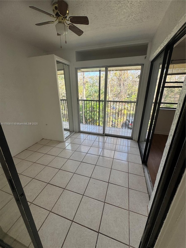 spare room featuring light tile patterned flooring, a textured ceiling, and ceiling fan