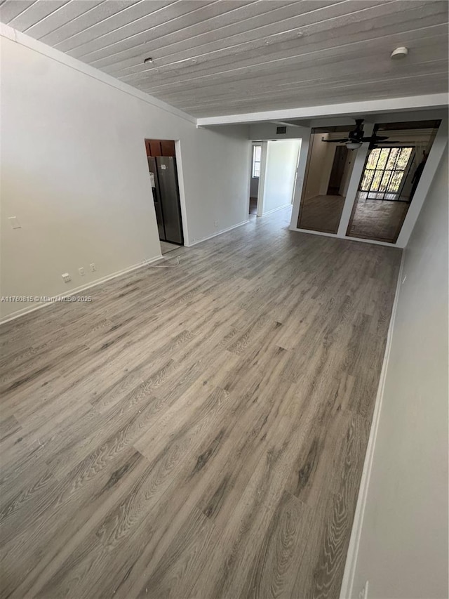 spare room with wooden ceiling, light wood finished floors, a ceiling fan, and a wealth of natural light