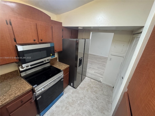 kitchen with appliances with stainless steel finishes and lofted ceiling