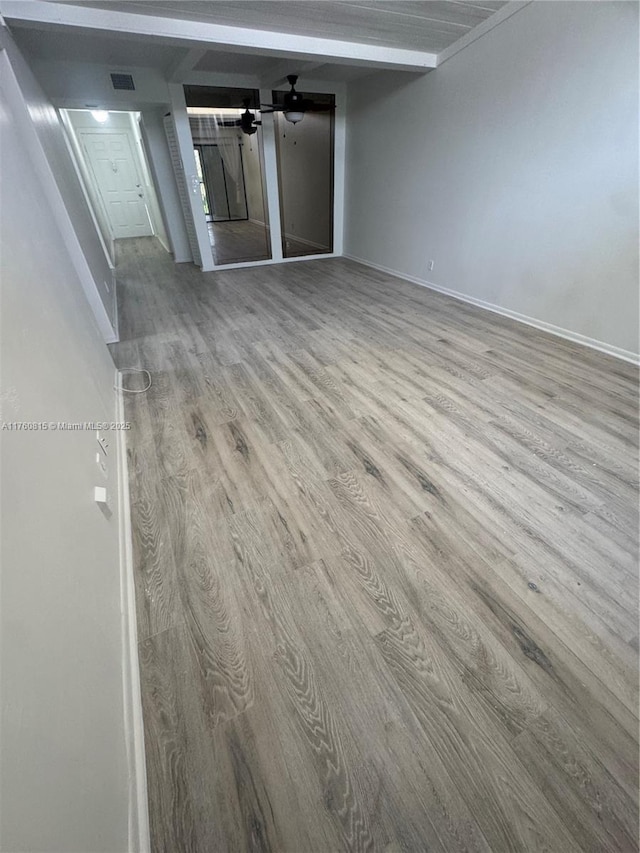 empty room with baseboards, wood finished floors, visible vents, and ceiling fan