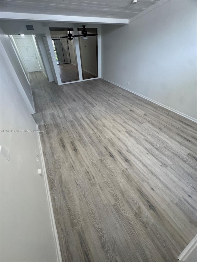 empty room with visible vents, ceiling fan, and wood finished floors