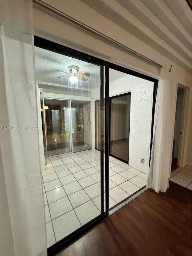 doorway to outside featuring wood finished floors and a textured wall