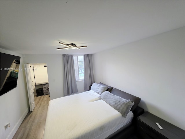 bedroom featuring baseboards, light wood-style floors, and a ceiling fan