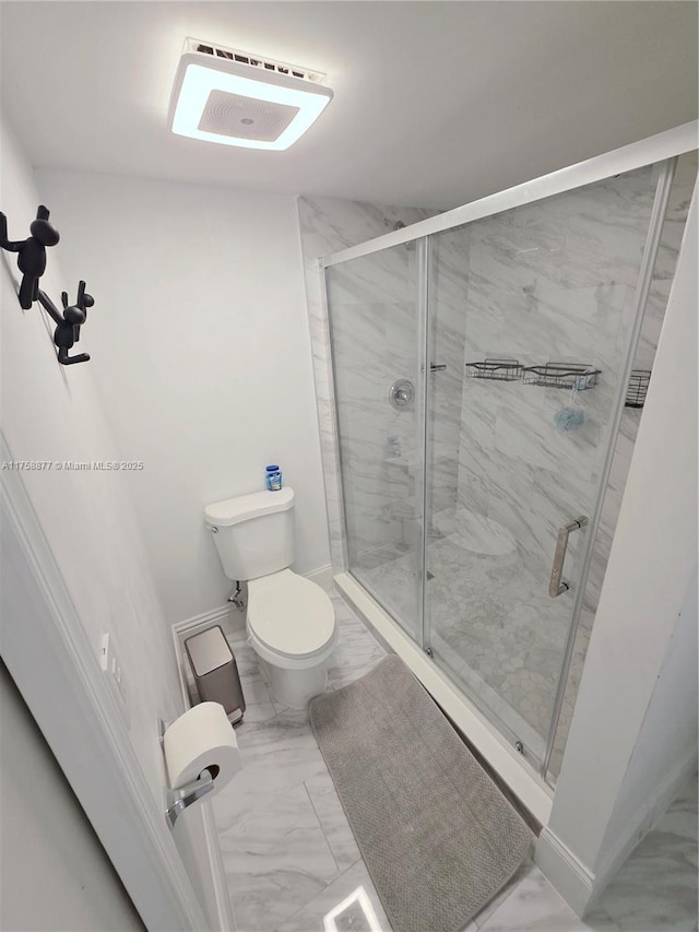 bathroom with a shower stall, toilet, and marble finish floor