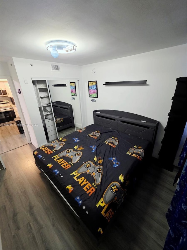 bedroom featuring wood finished floors and visible vents