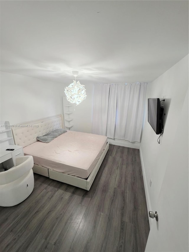 bedroom featuring baseboards and dark wood-style flooring