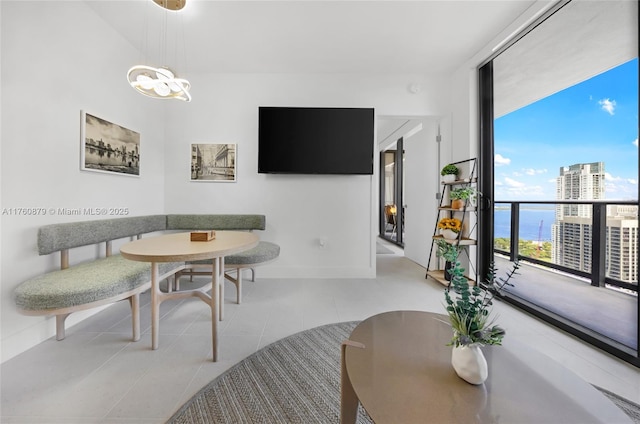 dining area featuring baseboards, tile patterned flooring, floor to ceiling windows, breakfast area, and a chandelier