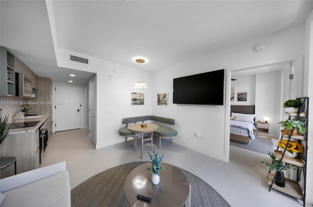 living area featuring light tile patterned floors, visible vents, recessed lighting, and baseboards