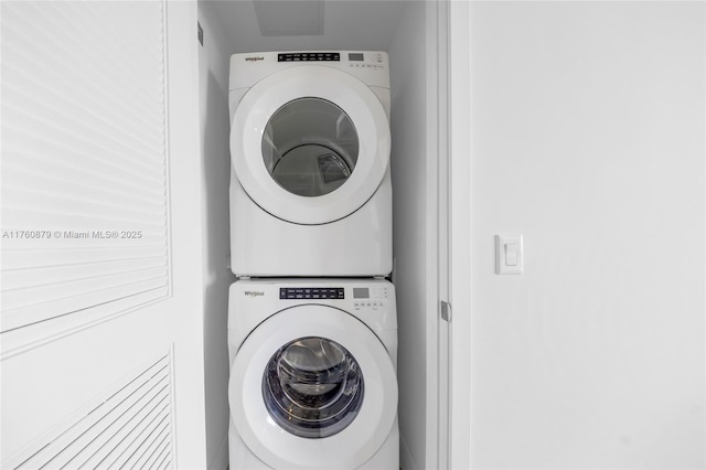 washroom featuring stacked washer / drying machine and laundry area