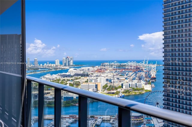 balcony with a water view and a view of city