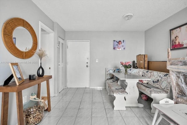 interior space featuring breakfast area, baseboards, and a textured ceiling