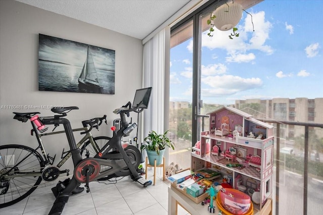 workout area with a wealth of natural light, floor to ceiling windows, tile patterned floors, and a textured ceiling