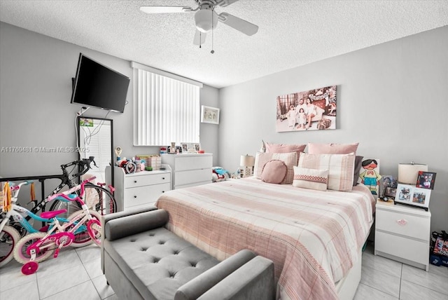 bedroom with a textured ceiling, light tile patterned floors, and ceiling fan