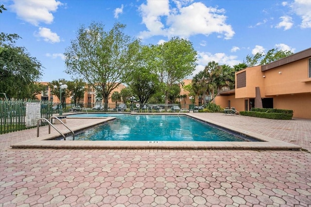 community pool featuring a patio and fence