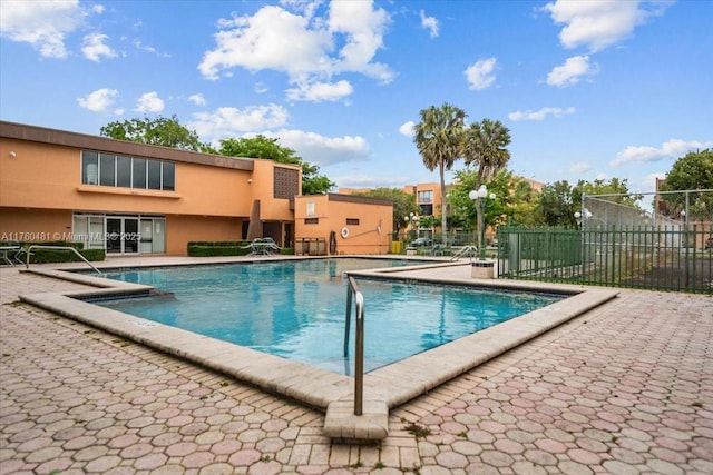 community pool featuring a patio and fence